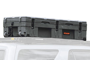ROAM 128L Rolling Rugged Case mounted on a vehicle roof rack with tie-down points visible
