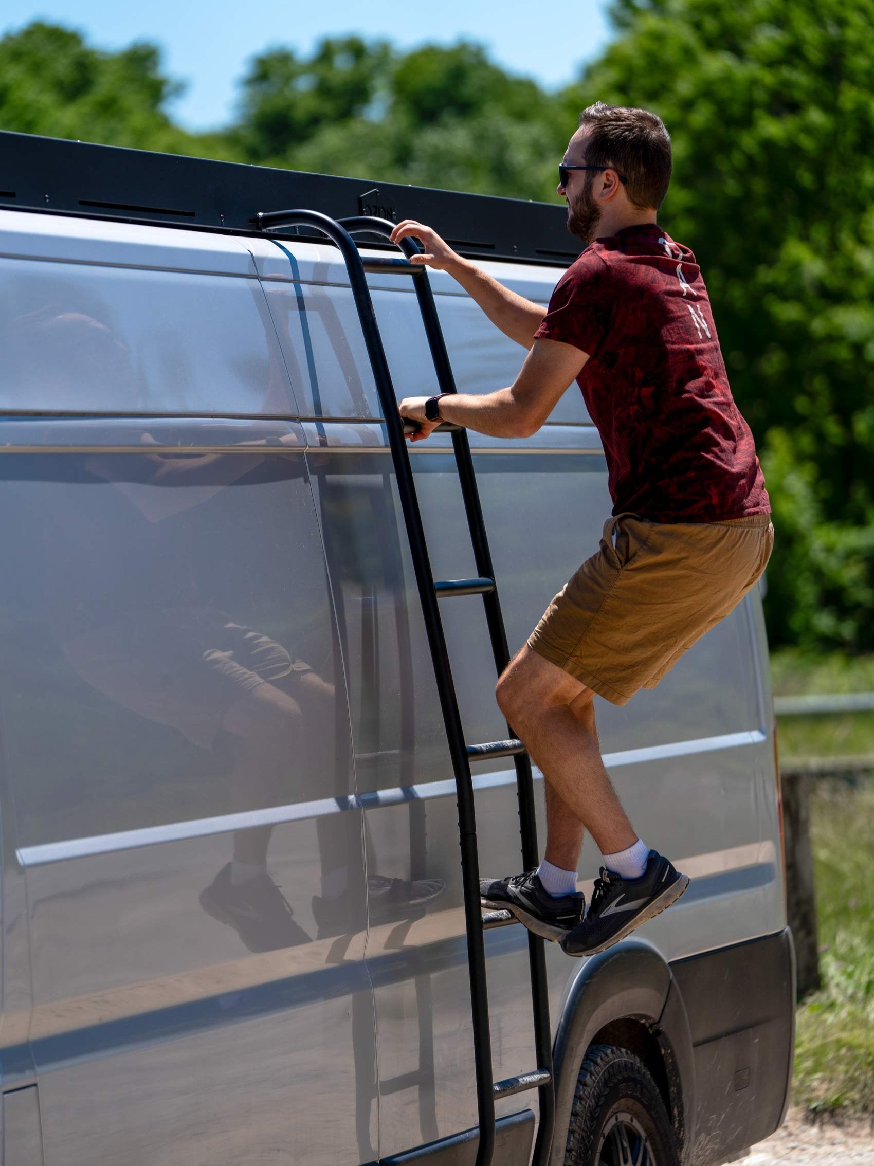 Man climbs orion van gear's promaster side ladder