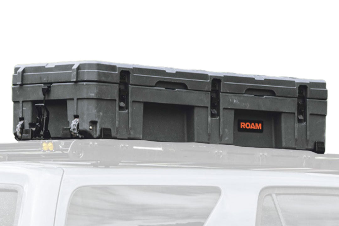 ROAM 128L Rolling Rugged Case mounted on a vehicle roof rack with tie-down points visible
