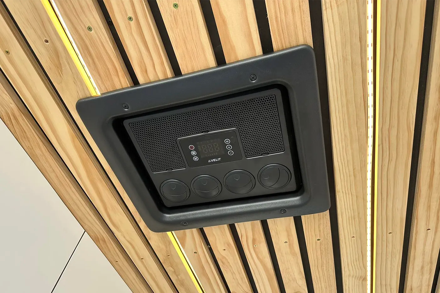 Black electronic device mounted on a wooden panel
