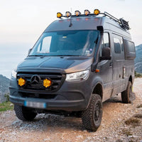 Mercedes-Benz van on a mountain road with off-road equipment.