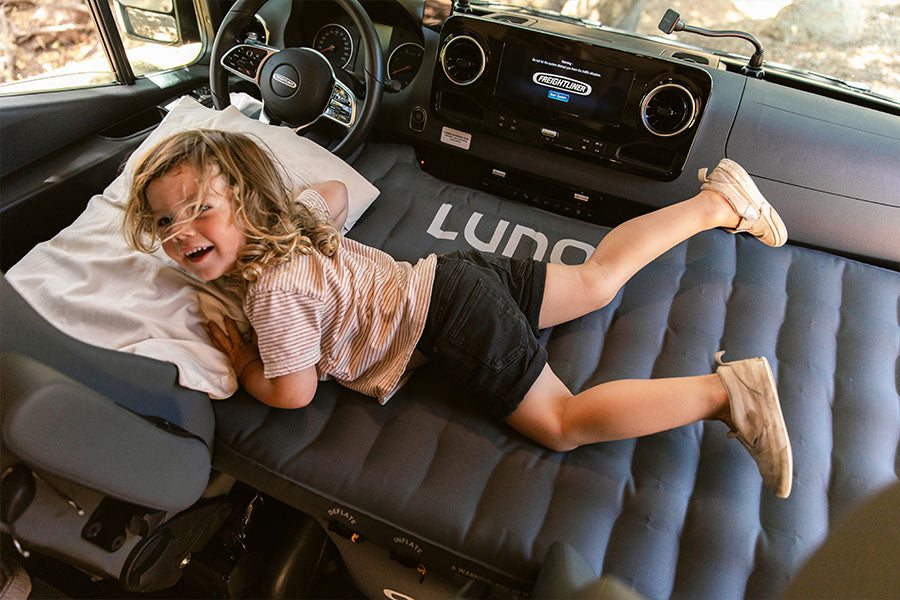 Boy on Luno Camper Van front cab mattress