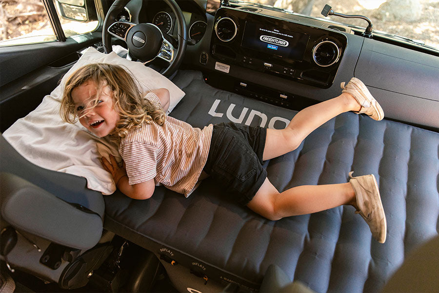 Kid laying on luno front cab van mattres 