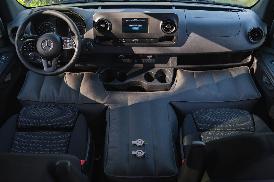 Interior of a vehicle with a T-shaped base extender for a flat sleeping surface.