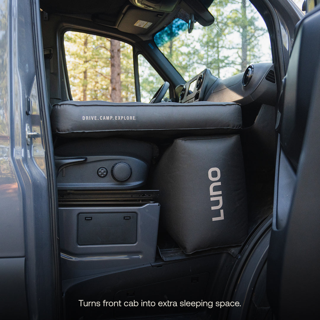 Interior of a vehicle with a sleeping pad labeled 'LUNO' and text indicating it can turn the front cab into an extra sleeping space.
