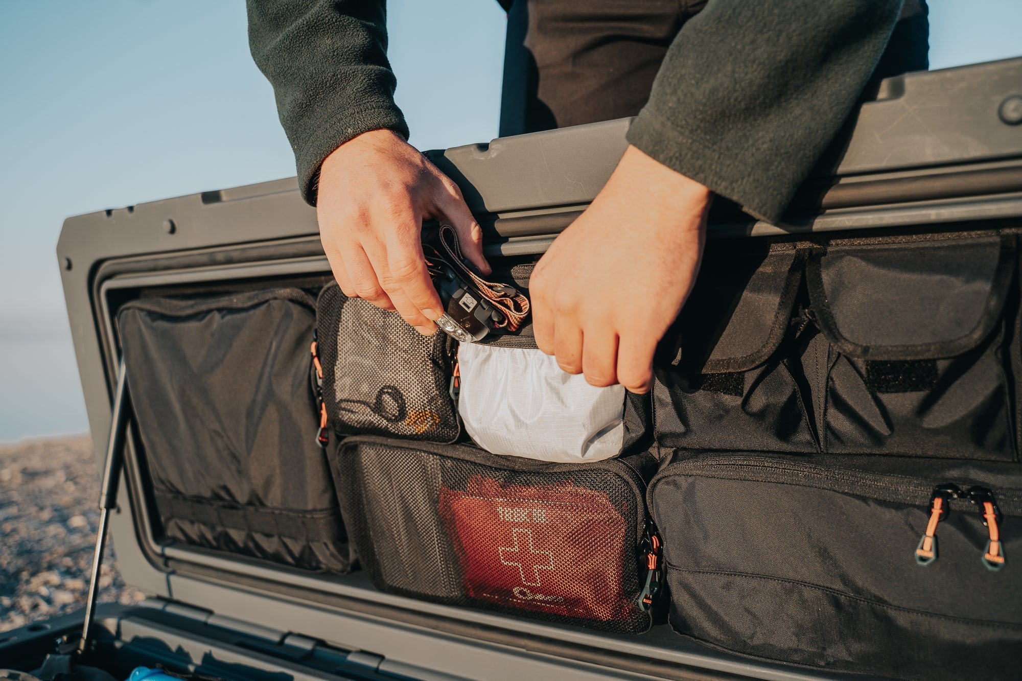 95L lid organizer - person putting headlamp into pocket