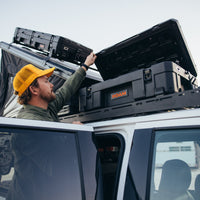 person opening roam 66L case on roof of vehicle 