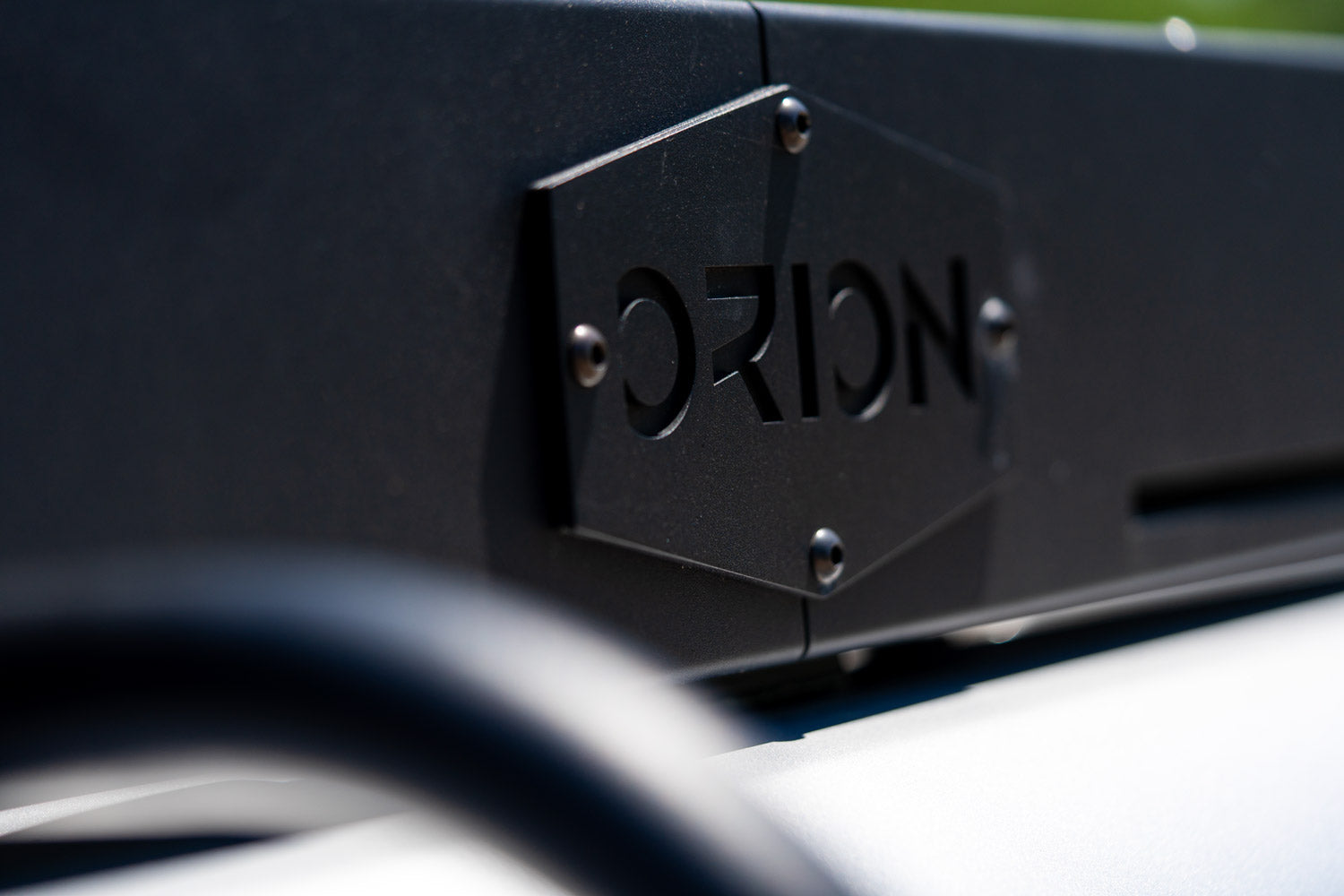 Close-up of the Orion Van Gear logo on a Ram Promaster roof rack, showcasing quality craftsmanship and adventure-ready design