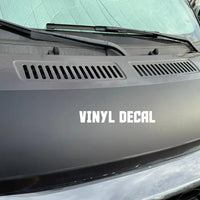Vinyl decal on a promaster van hood with text 'VINYL DECAL'. Base of the hood solar panel