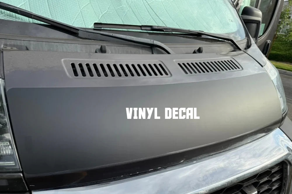 Vinyl decal on a promaster van hood with text 'VINYL DECAL'. Base of the hood solar panel