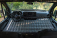 Inflatable mattress in the back of a vehicle with 'Luno' branding.