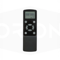 Black remote control with digital display on a white background