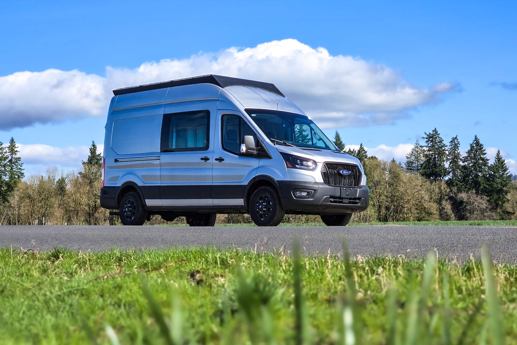 A ford tranist with orion van gear roof rack drives by