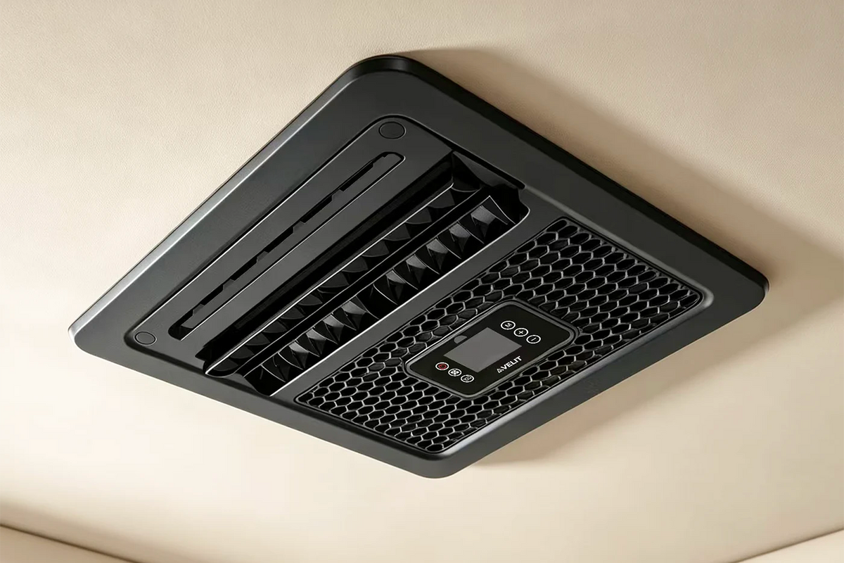 A black ceiling-mounted velit V3 air conditioner with a digital display and control buttons, installed on a beige ceiling.