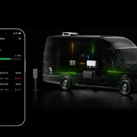 Smartphone showing EcoFlow app monitoring battery charging status inside a van with installed EcoFlow Power Kit system.