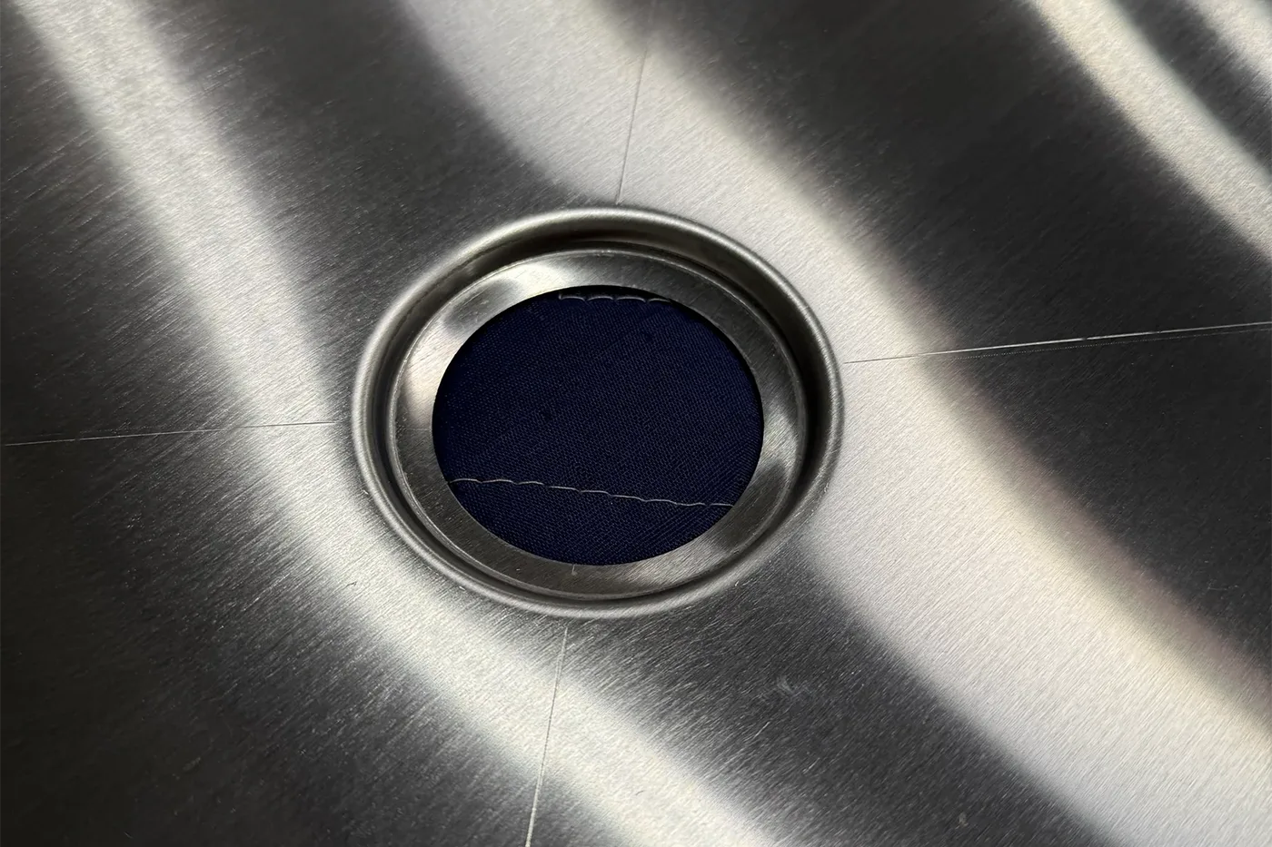 Close-up of stainless steel van shower pan drain area