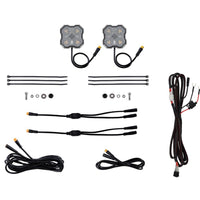 A kit of two square LED light modules with wiring, several black zip ties, mounting hardware, and connector cables, arranged neatly on a solid white background.