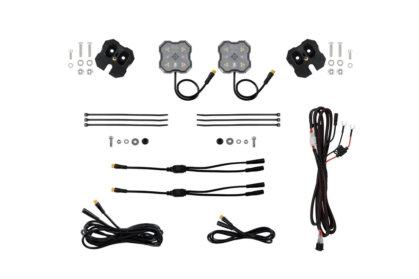 A complete wiring harness kit for vehicle lights, laid out on a clean white background. The kit includes two square LED light modules with attached wiring, two black mounting brackets with screws and washers, several black zip ties, and multiple black wire harnesses with various connector types.