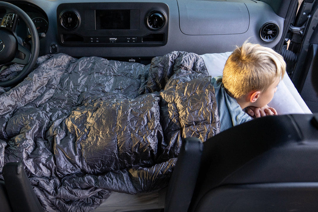 Child lying on a car seat cover in a vehicle with text 'Great for kids, small adults, & pets.'