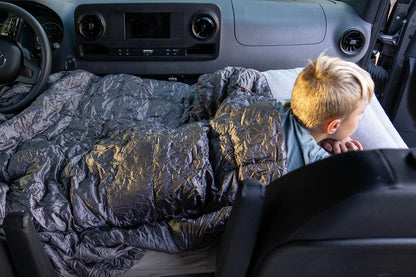 Child lying on a car seat cover in a vehicle with text 'Great for kids, small adults, & pets.'