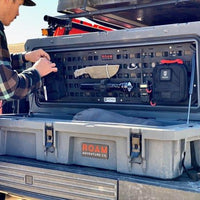 A person attatching items to a 105L Molle Panel insert for roam case