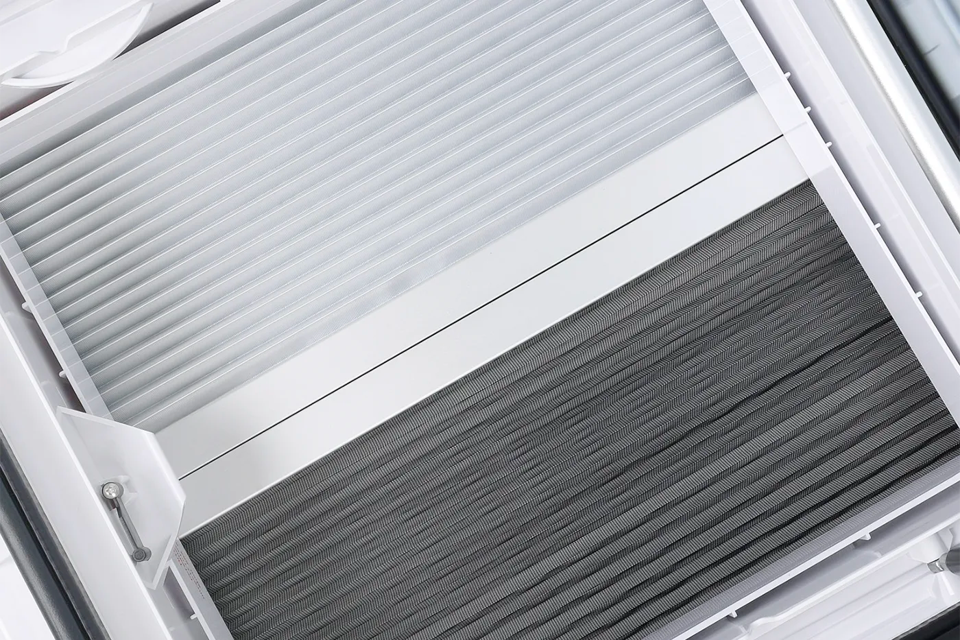 Close up of the NomadicArk 450 x 400 van and RV skylight with pleated blind and bug screen partially closed