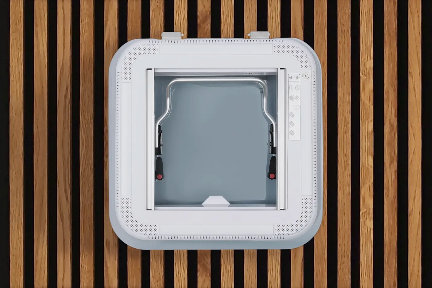 Interior view of the NomadicArk 450 x 400 van and RV skylight showing LED lights, handles, blind, and bug screen installed on wood slats on van ceiling 