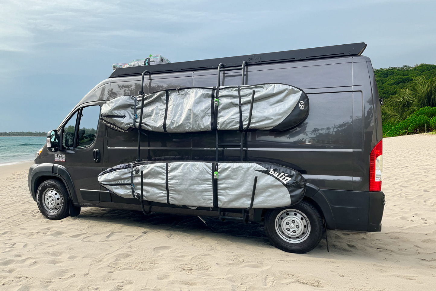 Promaster van with surfboard racks on a beach - orion van gear - secured with kanulock straps