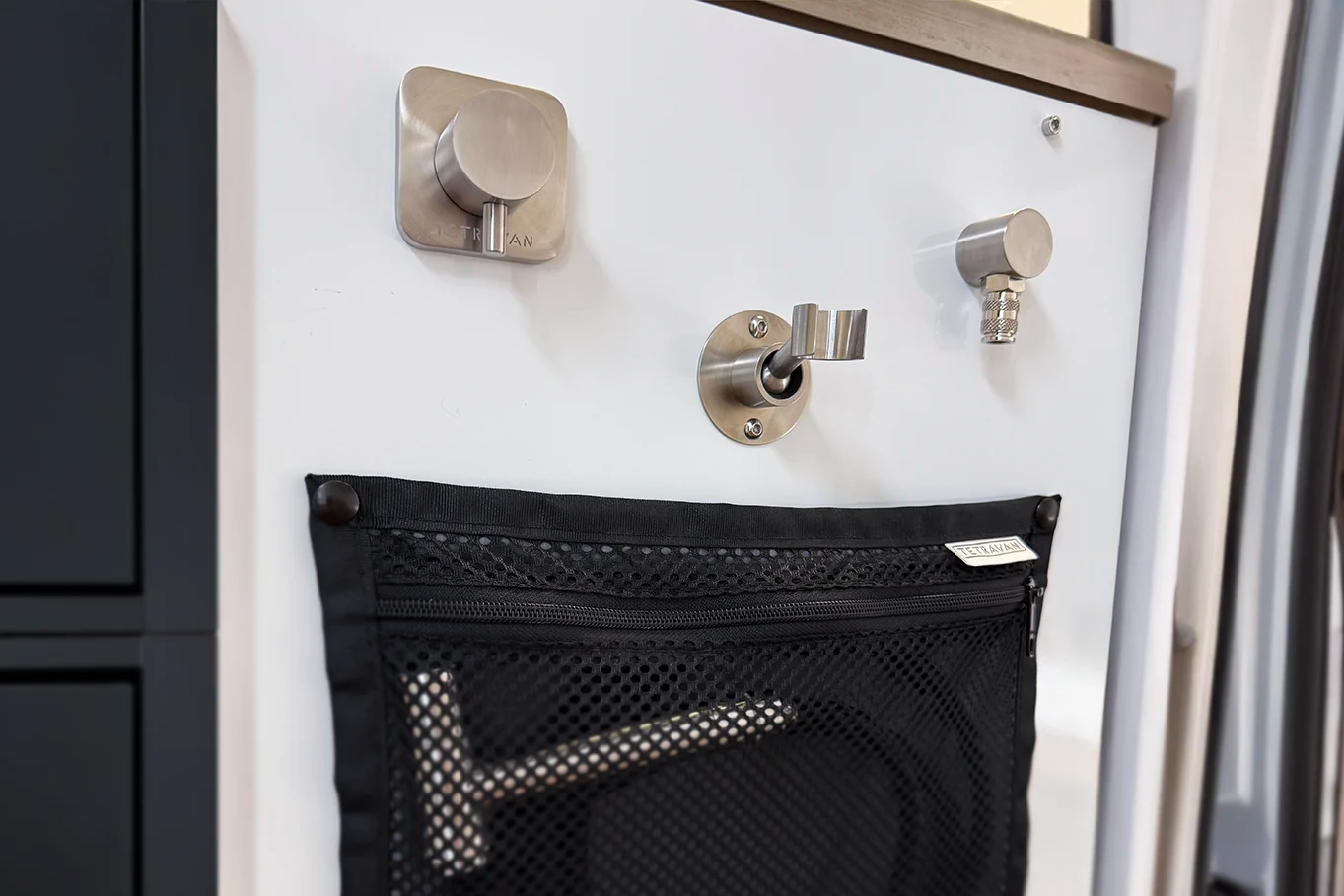Tetravan shower port system with storage pouch and plumbing hoses