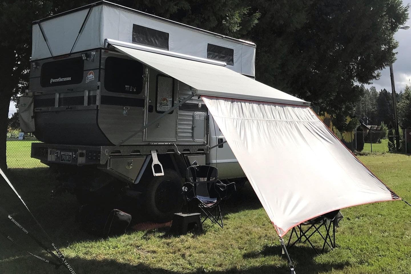 Awning Extension shown on a 4Wheel Camper with an Fiamma F45s 260 awning. Red Trim, black patches, Grey Tarp